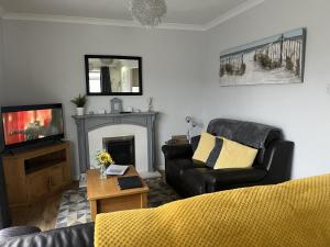 ブリドリントンにあるSeasideEscape-2Br-Sleeps4-Parking-PetsOK-Fireplaceのソファとテレビのあるリビングルーム