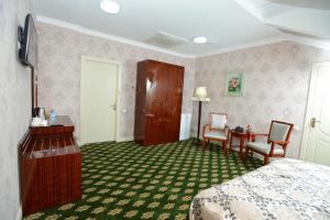 a hotel room with a bed and a table and chairs at City Line Boutique Hotel in Tashkent