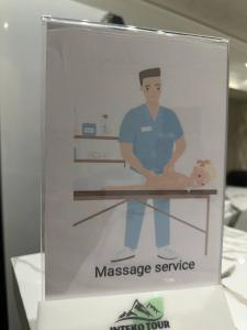 a sign for a massage service on a table at Guest House Bekturdi in Khiva