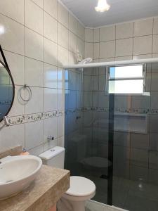 a bathroom with a sink and a toilet and a mirror at Residencial Vô Joca in Palhoça +41 photos