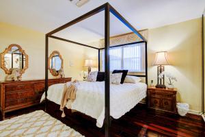 1 dormitorio con 1 cama con dosel y 2 espejos en Classic Modern 3-Bedroom Oasis, en Fort Lauderdale