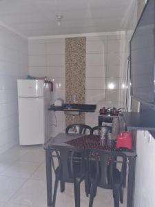 a kitchen with a table and chairs and a refrigerator at Casa Atenas 2 in Três Lagoas