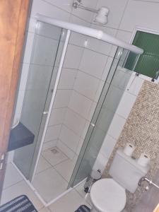 a bathroom with a toilet and a glass shower at Casa Atenas 2 in Três Lagoas +5 photos