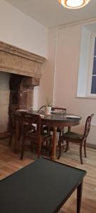a dining room with a table and chairs and a fireplace at La chambre des notaires in Moulins