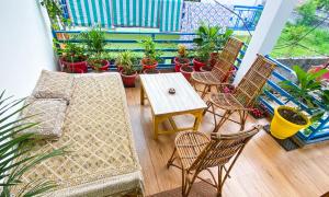 a balcony with chairs and a table and potted plants at Comfort & Cozy, Villa in Orchha