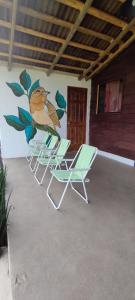 four chairs and a wall with a bird painted on it at Cabañas Tres Soles in Xico