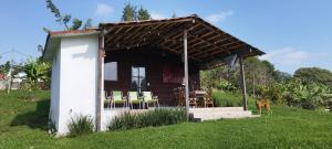 a small cabin with chairs in a field at Cabañas Tres Soles in Xico