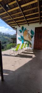 a group of chairs lined up against a wall with a bird painted on it at Cabañas Tres Soles in Xico +3 photos