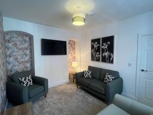 a living room with two couches and a flat screen tv at 8 Guests Large cottage Hotub in Hornsea