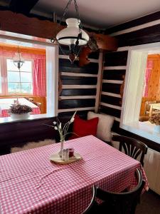 a dining room with a table with a red and white checkered table cloth at Bílá Labuť Pec in Pec pod Sněžkou