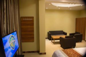 una camera d'albergo con TV e soggiorno di Hong Kong Hotel a Dar es Salaam