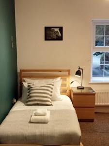 a bedroom with a bed and a lamp and a window at Quarrie House in Cramlington