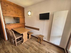 Pokój z drewnianym stołem i lodówką w obiekcie Résidence Rond Point Des Pistes C - Studio·Proche des pistes·Balcon MAE-7584 w mieście Tignes