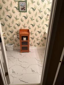 ein Badezimmer mit Toilette und einem kleinen Holztisch in der Unterkunft Pawleys Island Retreat! in True Blue