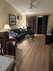 ein Wohnzimmer mit einem blauen Sofa und einem Sessel in der Unterkunft Pawleys Island Retreat! in True Blue