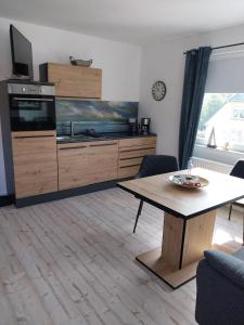 a living room with a table and a kitchen at Ferienwohnung Schnelzer in Sahlenburg