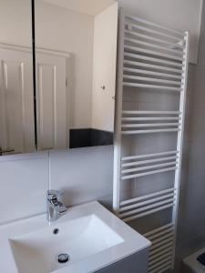 a white bathroom with a sink and a mirror at Ferienwohnung Schnelzer in Sahlenburg +13 photos