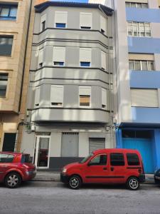 a red van parked in front of a building at Viviendas plaza del tronco 2 in Ferrol