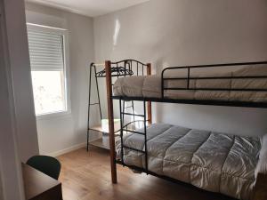 a bedroom with two bunk beds and a window at Viviendas plaza del tronco 2 in Ferrol