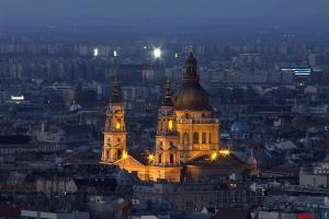 a large building with a clock tower at night at Révay 6 Suites by Corall in Budapest
