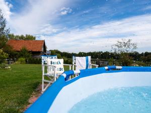 a pool with two chairs and a sign in a yard at Zacisze Rostken, Wypoczynek na Mazurach, Dom Całoroczny z Prywatną Plażą in Ostrów