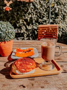 a cup of coffee and two sandwiches on a wooden table at Hotel Rosa Viva in Barretos