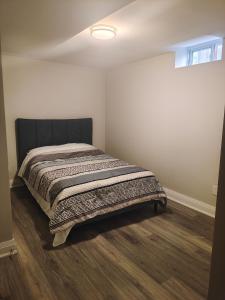 a bedroom with a bed with a blanket on it at Tom oker in Mississauga