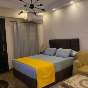 une chambre avec un lit avec une couverture jaune dessus dans l'établissement Studio near airport, au Caire 56 autres photos