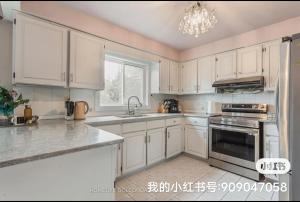 a white kitchen with white cabinets and a window at Tom oker in Mississauga +10 photos