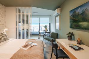 a room with a bed and a desk and a table at ZENHAUS - Moderno en Punta Carretas con Vistas a la Ciudad in Montevideo