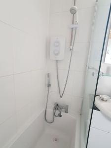 een douche in een witte badkamer met een wastafel bij Spaside Apartment in Scarborough +29 foto's