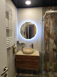 une salle de bain avec un lavabo et un miroir dans l'établissement By the sea16, à Batoumi