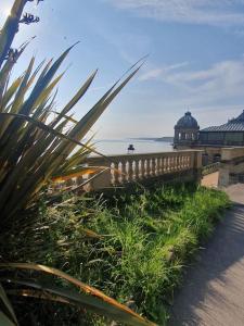 een hek naast een strand met een gebouw en de oceaan bij Spaside Apartment in Scarborough