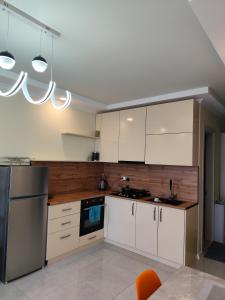 une cuisine avec des armoires blanches et une cuisinière dans l'établissement By the sea16, à Batoumi