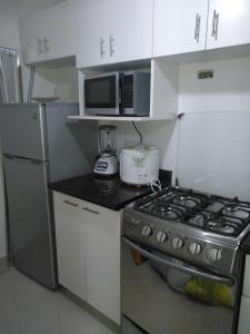 a kitchen with a stove and a microwave at Apartamento en Centro Historico de Lima in Lima +36 photos
