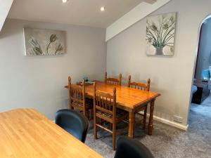 a dining room with a wooden table and chairs at Eagle Cottage in Penrith +4 photos