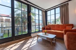 a living room with a couch and large windows at Villa Elena - Dolni Saraj in Ohrid
