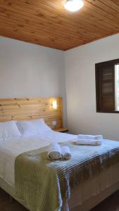 a bedroom with a bed with two towels on it at Morada da colina casa de campo in Santo Antônio do Pinhal
