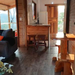 a living room with a couch and a kitchen at Morada da colina casa de campo in Santo Antônio do Pinhal