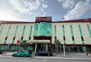 a building with two cars parked in front of it at Meral Crown Hotel in Riyadh