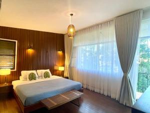ein Schlafzimmer mit einem Bett und einem großen Fenster in der Unterkunft Mid-Century Modern Centrally Located Garden Oasis in Baguio City