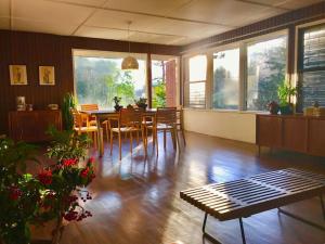 ein Wohnzimmer mit Esstisch und Stühlen in der Unterkunft Mid-Century Modern Centrally Located Garden Oasis in Baguio City