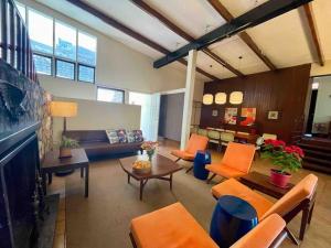ein Wohnzimmer mit orangefarbenen Stühlen und einem Sofa in der Unterkunft Mid-Century Modern Centrally Located Garden Oasis in Baguio City
