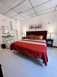 Un dormitorio con una cama grande con una manta roja. en The Cowboy Bunkhouse, en Kanab