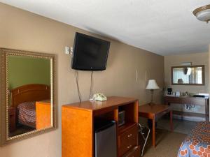 Una habitación de hotel con una cama y un televisor en la pared. en American Star Inn, en Baird