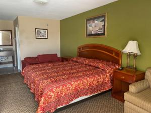 una habitación de hotel con una cama y una silla en American Star Inn, en Baird