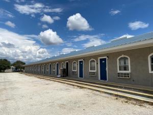 un edificio largo con puertas azules a su lado en American Star Inn, en Baird