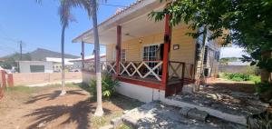 a yellow house with a red balcony on it at Villa Tutilia in Willemstad
