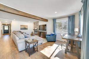 un salon avec un canapé et une table dans l'établissement Cozy Waterfront Hale Cottage on Long Lake!, à Lupton