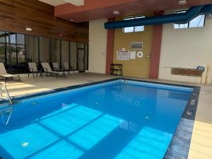 a large swimming pool in a building with chairs at Sycamore Suites in Elyria